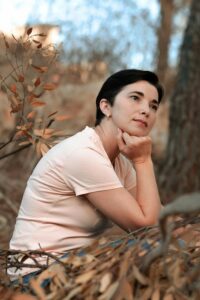 femme-pensive-menopause Femme pensive dans la nature, questionnement intérieur à la ménopause.
